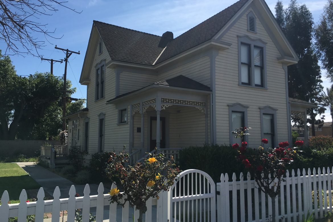 The historic Ware-Stanley House with its white picket fence and garden roses